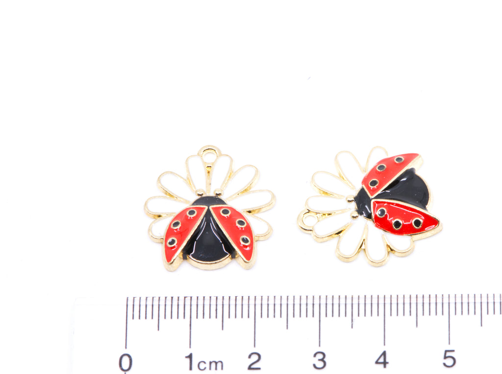 Two ladybug flower charms shown next to a cm ruler for scale on a white background.