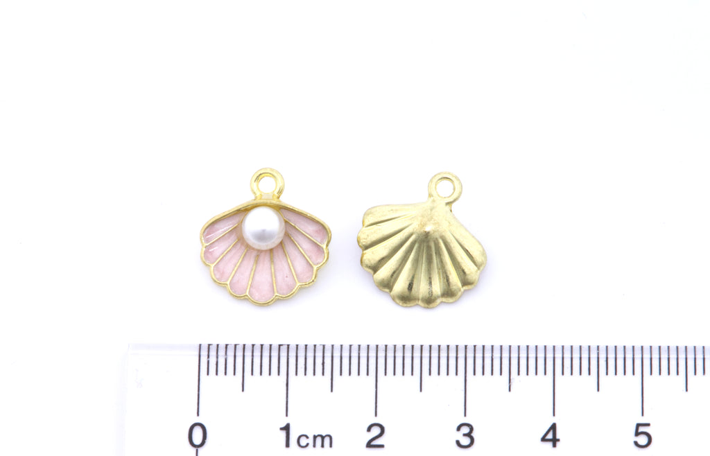 Two small shell-shaped jewelry charms shown on a white background with a ruler at the bottom for scale. 