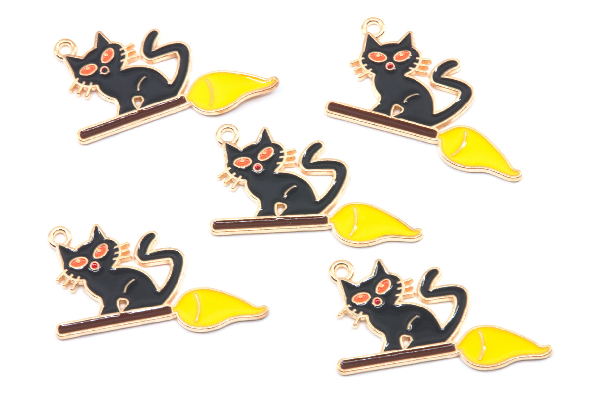 Five identical enamel charms of a black cat sitting on a yellow broomstick, arranged on a plain white background.
