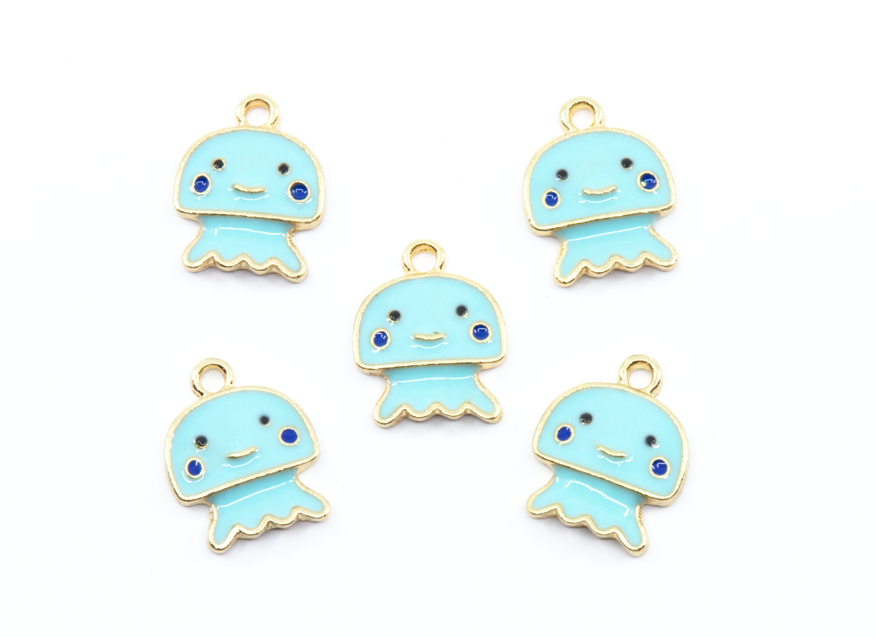 Five light blue jellyfish charms with gold-tone metal borders, small blue gemstone eyes, and black facial features, arranged on a plain white background.