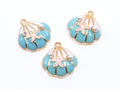 Three seashell-shaped jewelry charms with turquoise blue enamel, gold-tone metal borders, pink starfish details, and small pearl accents on a white background.