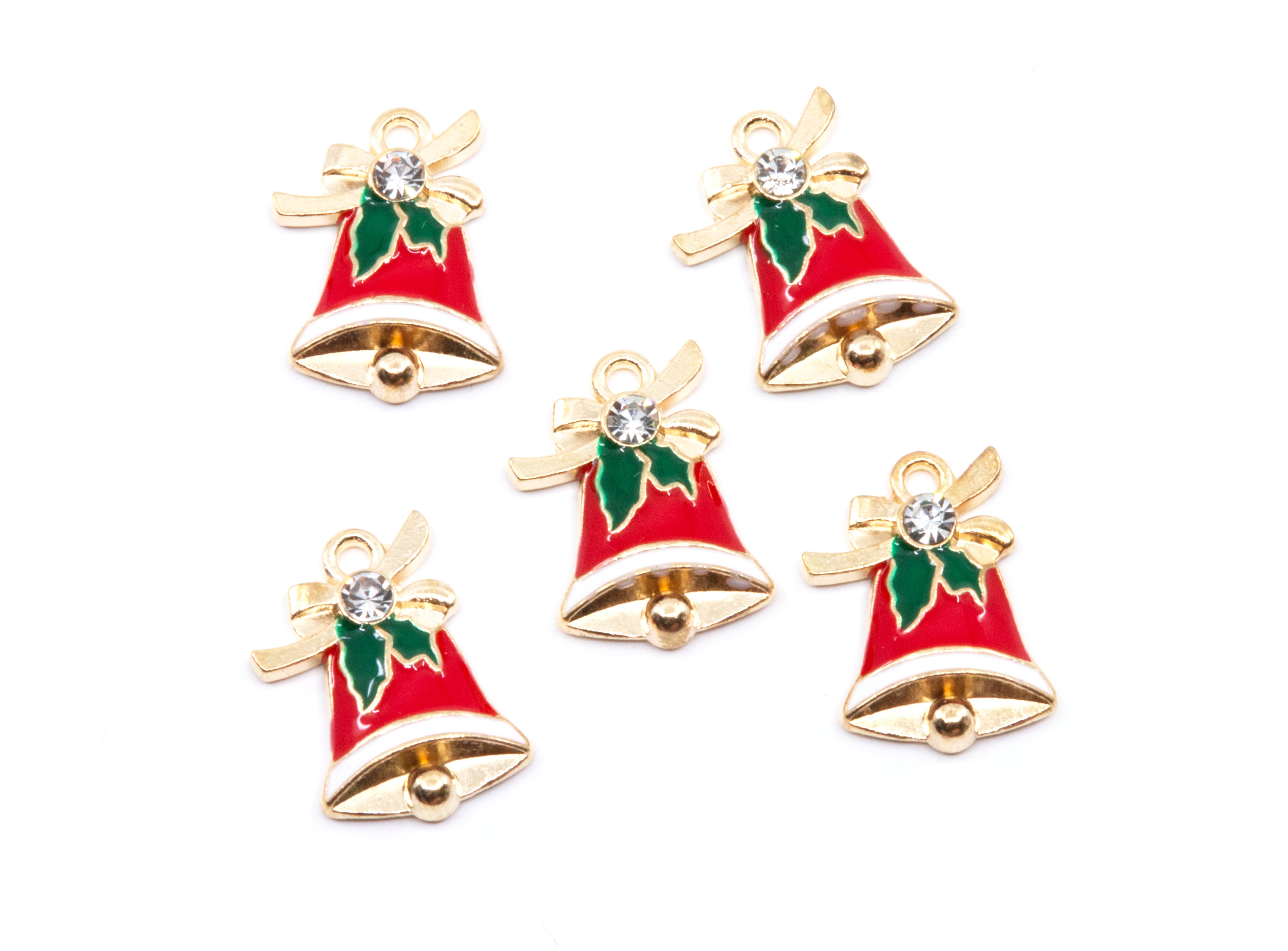 Five Christmas bell charms with red enamel, gold-tone metal borders, green holly leaves, and a clear rhinestone, arranged on a white background.