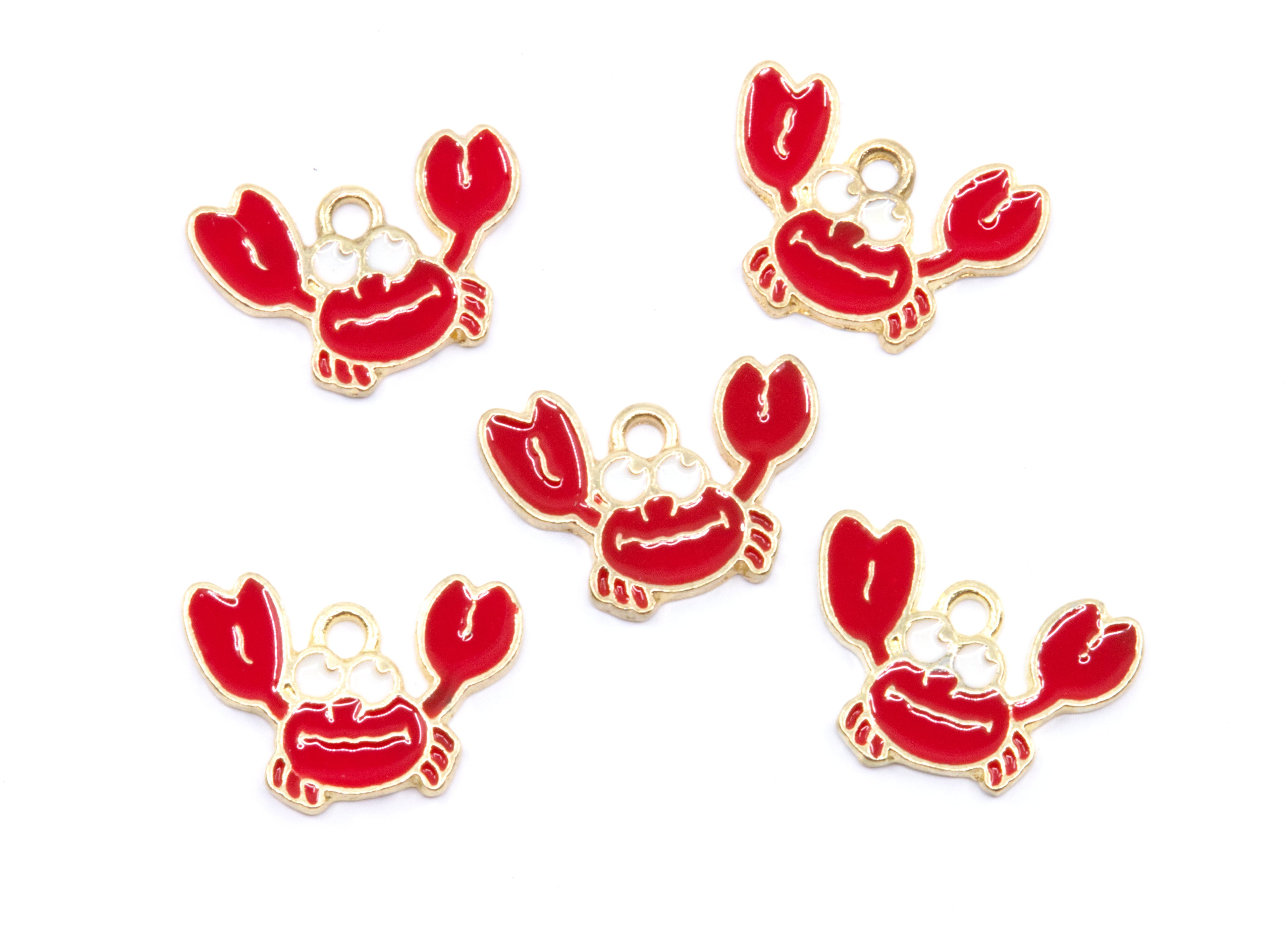 Five red crab charms with gold metal outlines and loops, arranged on a plain white background.