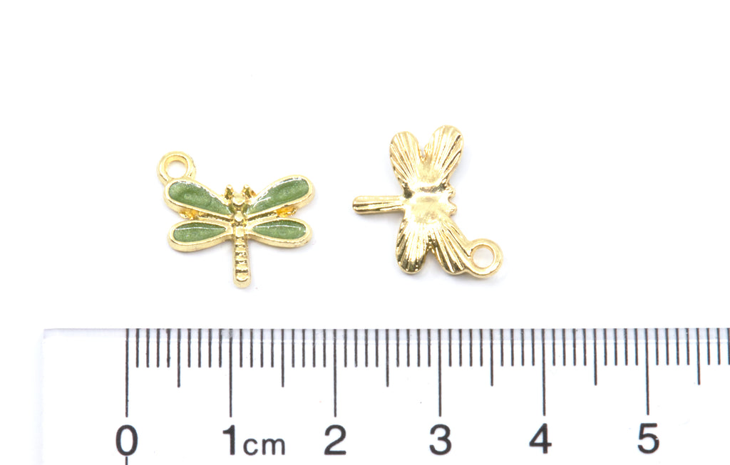 Two small dragonfly-shaped jewelry findings or charms shown on a white background cm ruler below for scale.