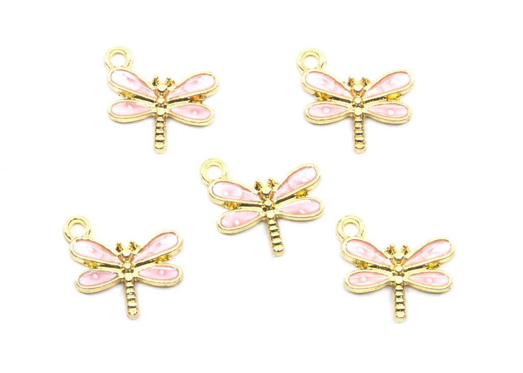 Five dragonfly charms with pink enamel wings and gold-tone metal bodies, arranged on a plain white background.