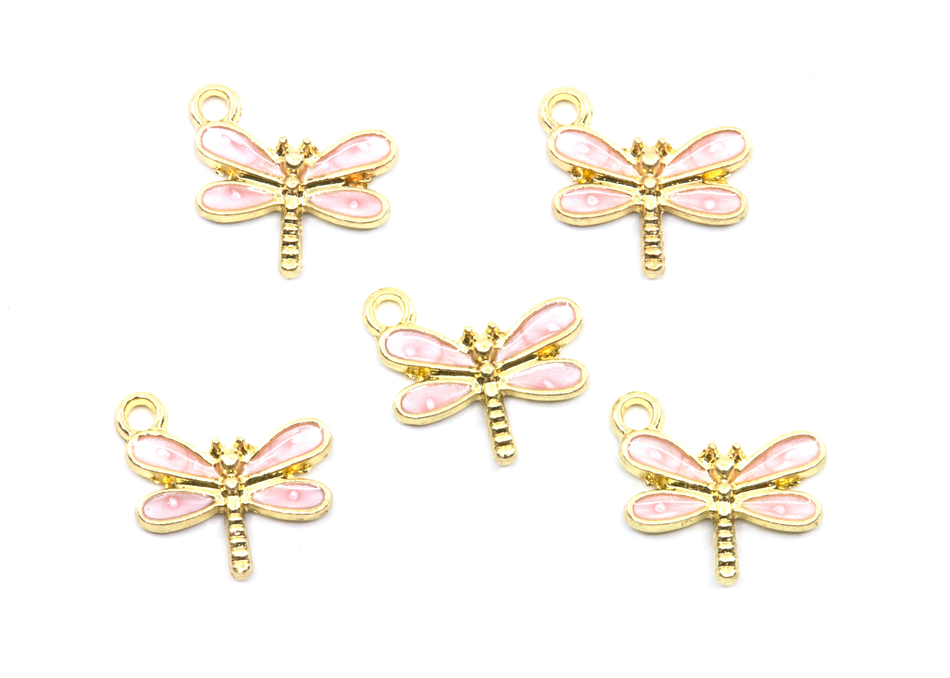 Five dragonfly charms with pink enamel wings and gold-tone metal bodies, arranged on a plain white background.