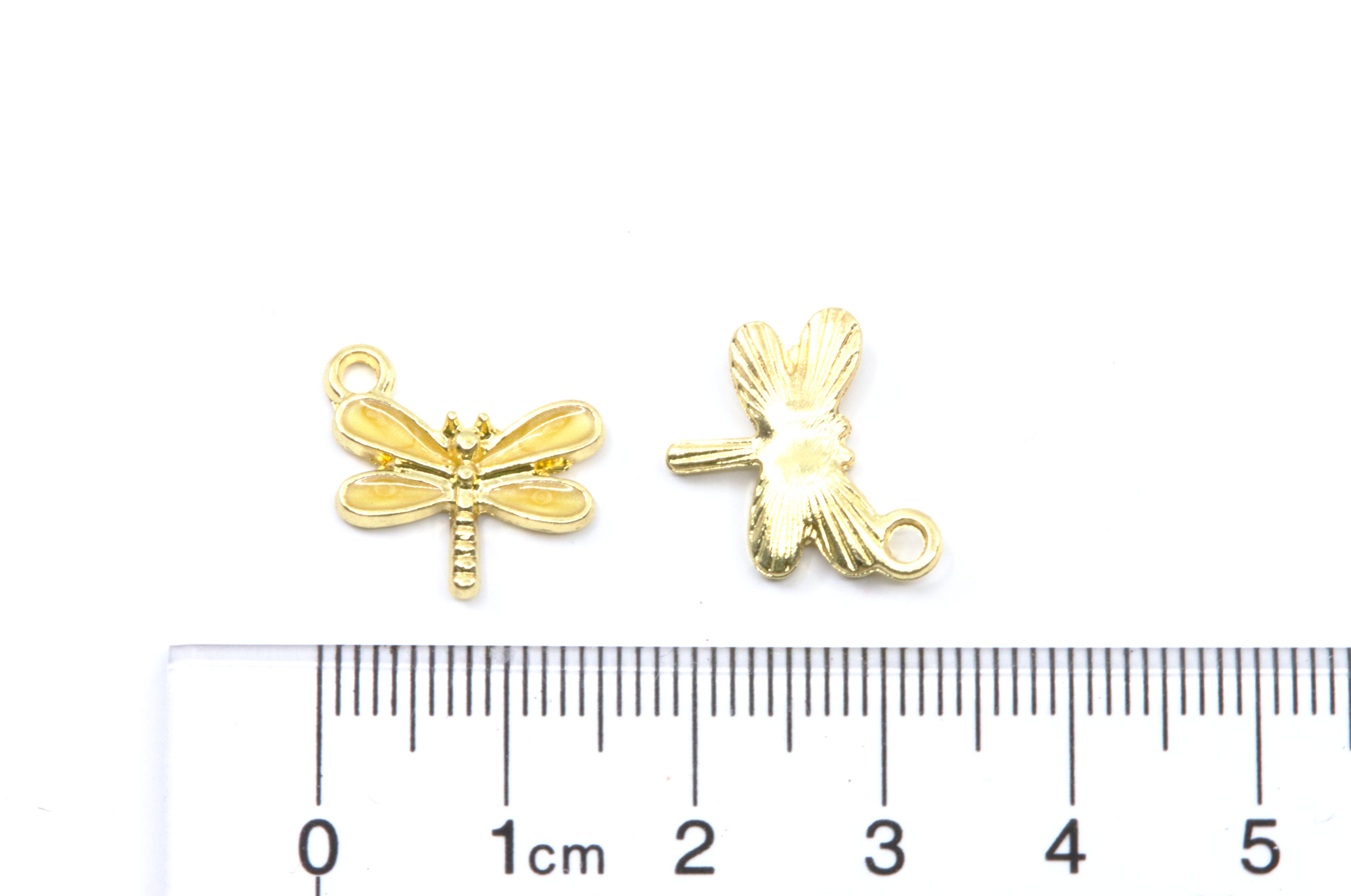 Two small gold dragonfly charms shown on a white background with a cm ruler below for scale.