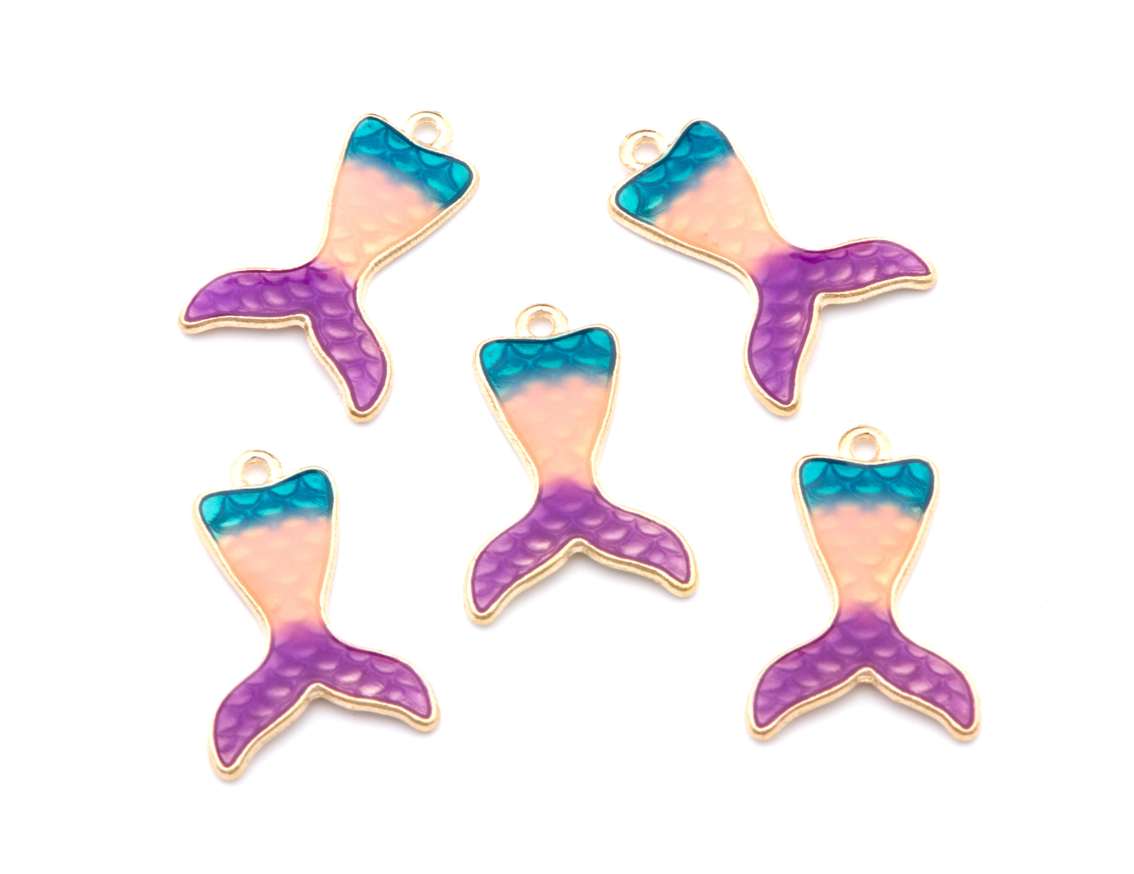 Five mermaid tail charms with a gold-tone outline, featuring a color gradient from teal blue to pink and purple, arranged on a plain white background.