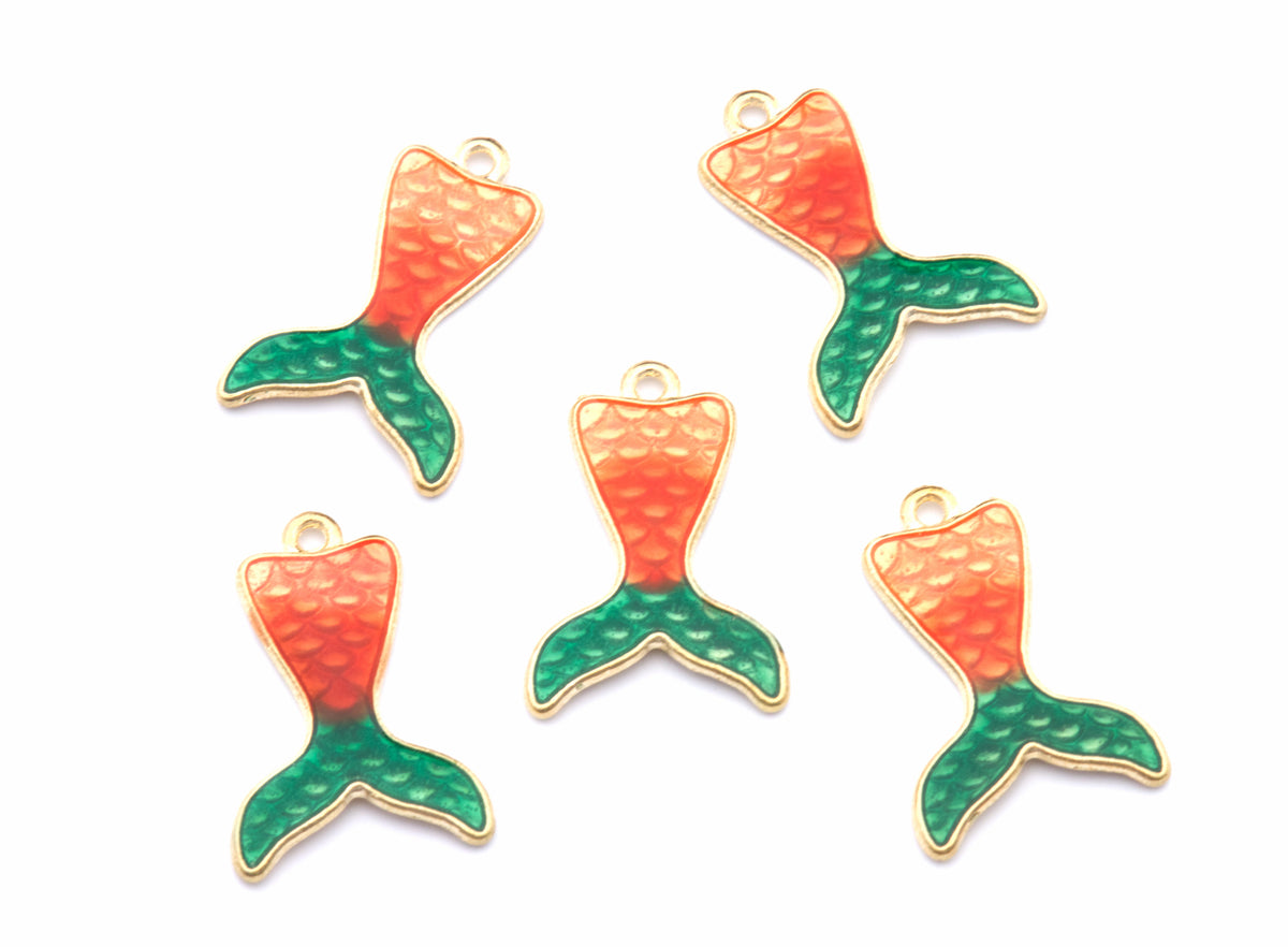 Five mermaid tail charms with a textured orange-to-green gradient enamel finish and gold-tone borders, arranged on a plain white background.