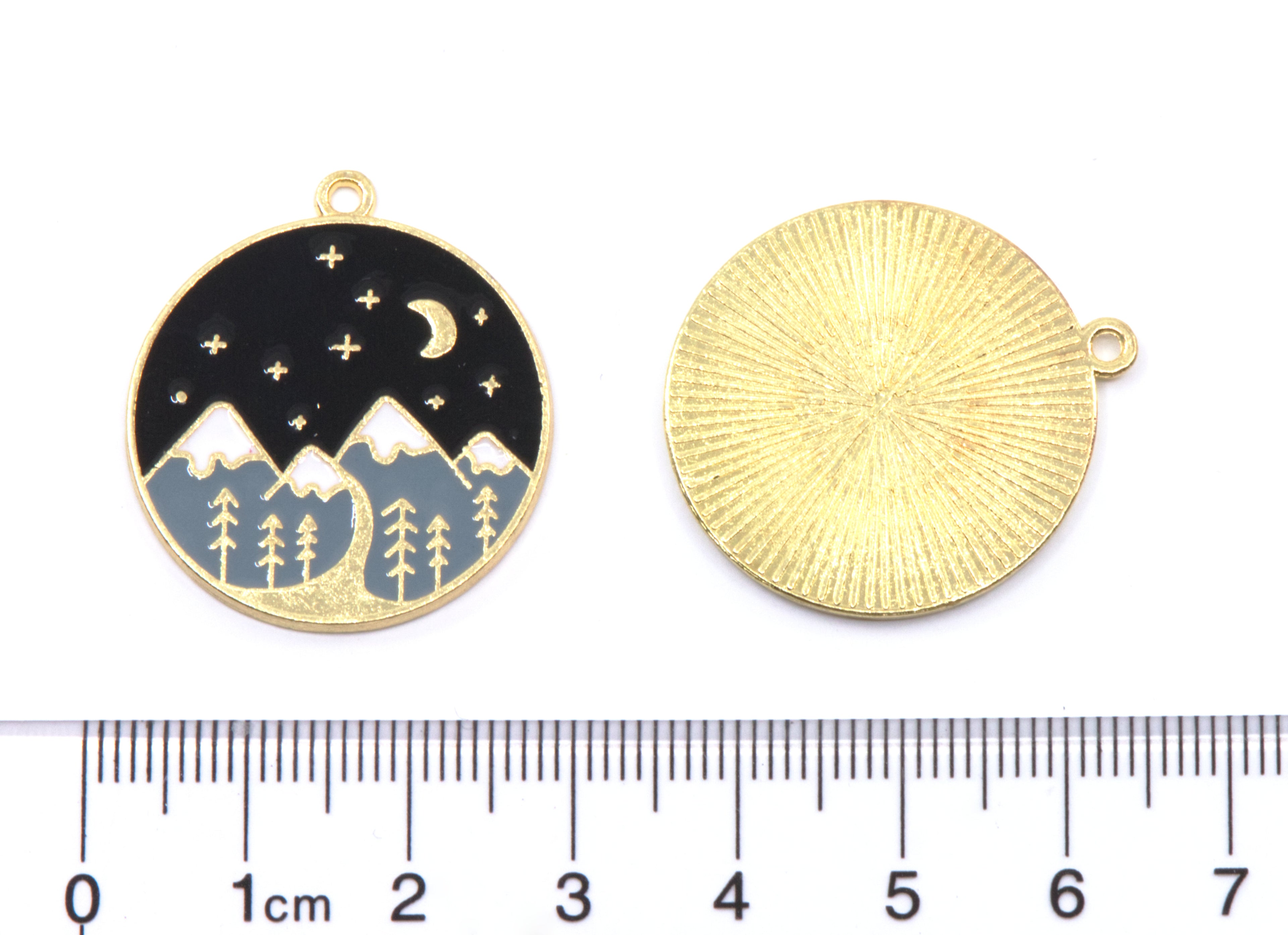 Two round mountain scenery  jewelry charms shown side by side on a white background, with a ruler at the bottom indicating scale. 