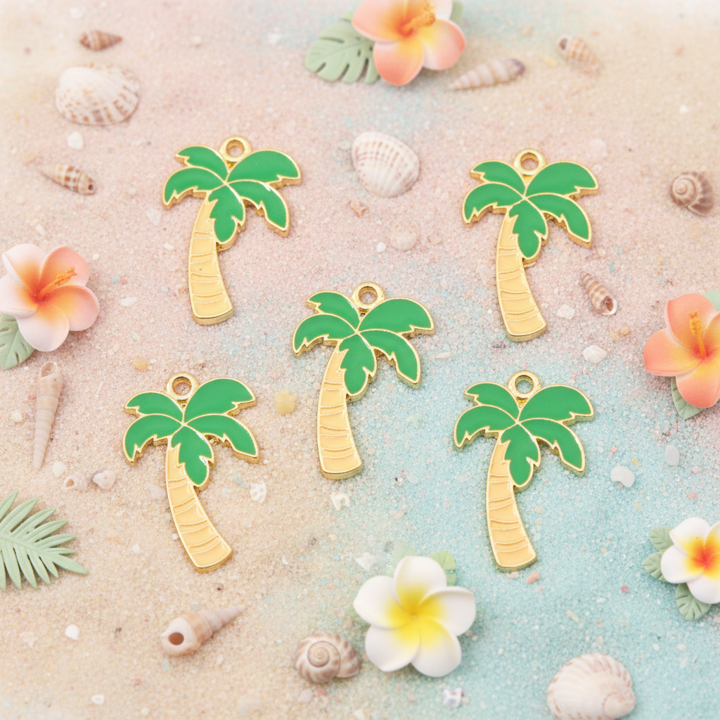 Five small palm tree charms with green leaves and light brown trunks arranged on a sandy surface with seashells and tropical flowers around them.