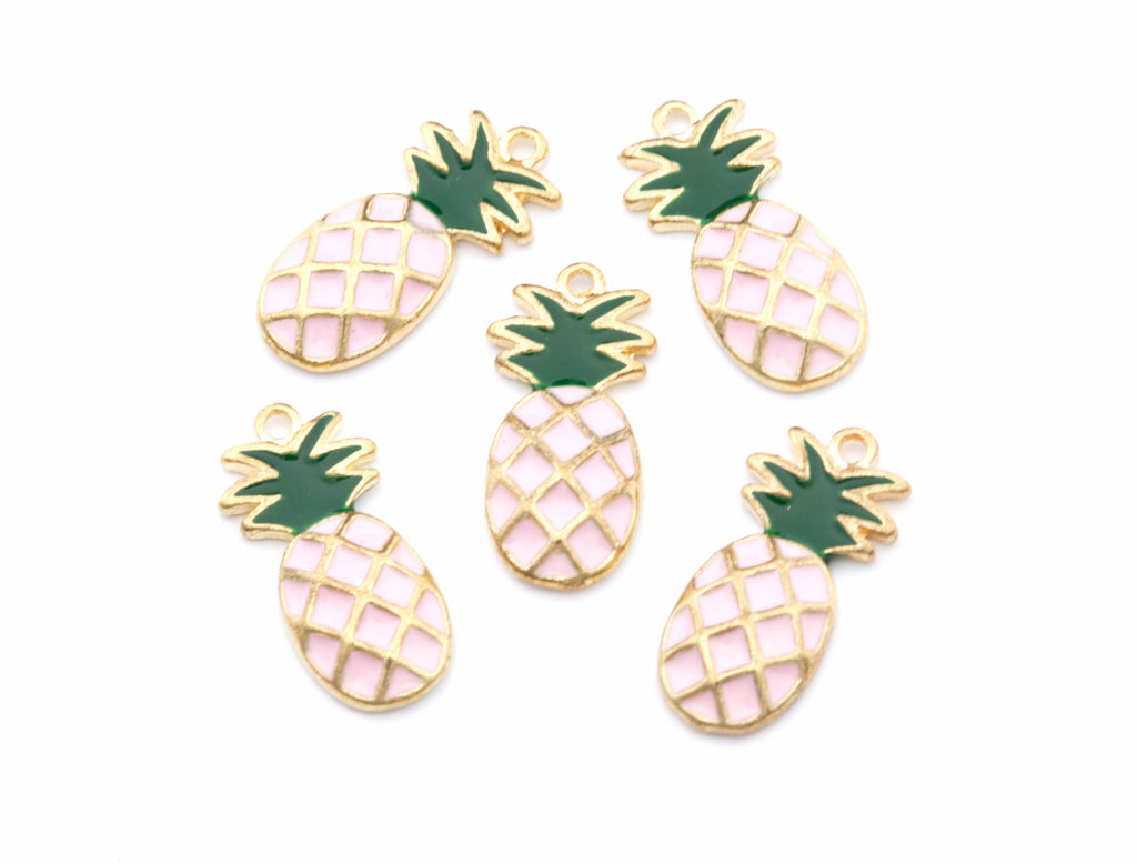 Five pineapple-shaped jewelry charms with gold-tone metal outlines, light pink enamel bodies, and dark green crown tops, arranged on a plain white background.