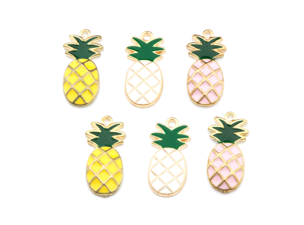 Six pineapple-shaped enamel charms with gold-tone metal outlines, arranged on a plain white background. The charms feature yellow, white, and light pink fillings with green tops.