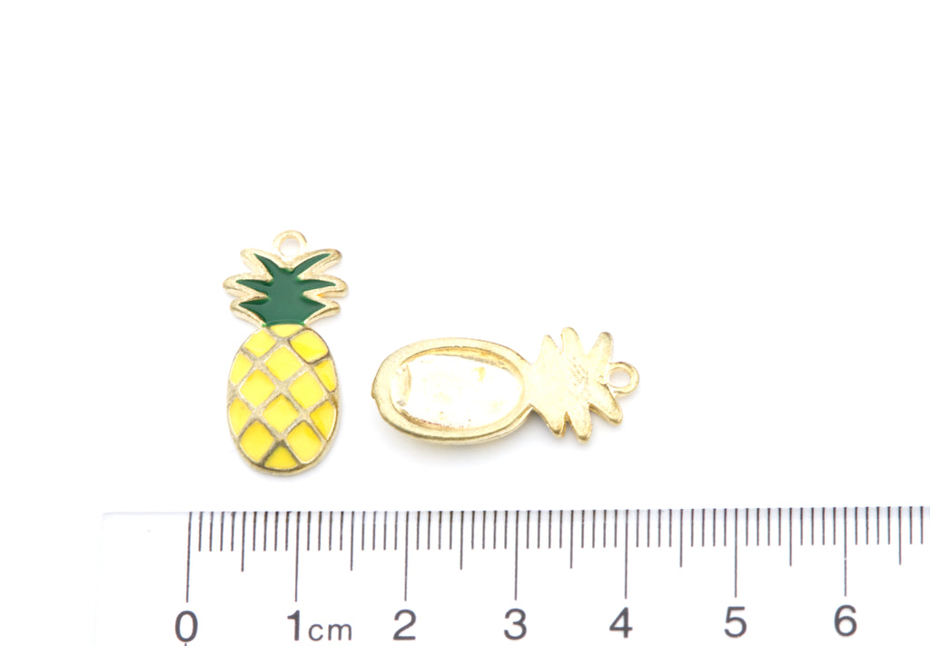 Two small pineapple-shaped jewelry charms shown on a white background with a ruler at the bottom for scale. 