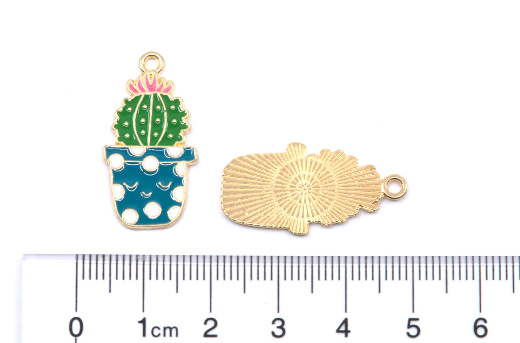 Two small green cacti charms with blue pot jewelry charms shown on a white background with a ruler at the bottom for scale. 