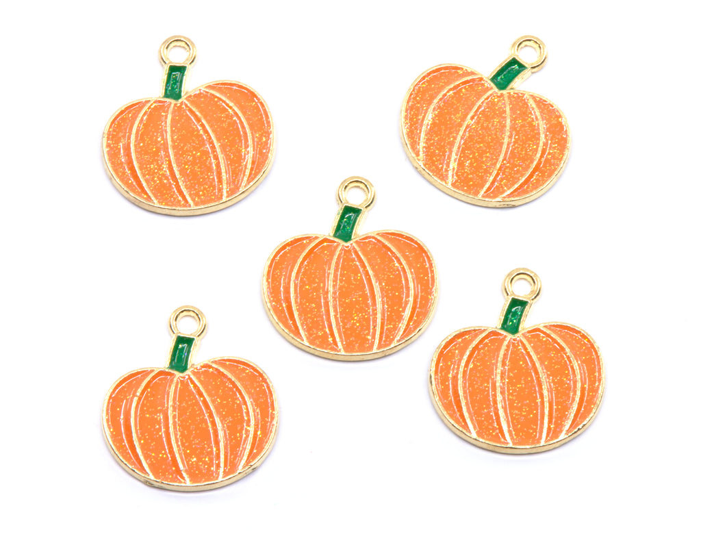 Five orange pumpkin-shaped charms with gold metal borders, white vertical stripes, and small green stems, arranged on a plain white background.