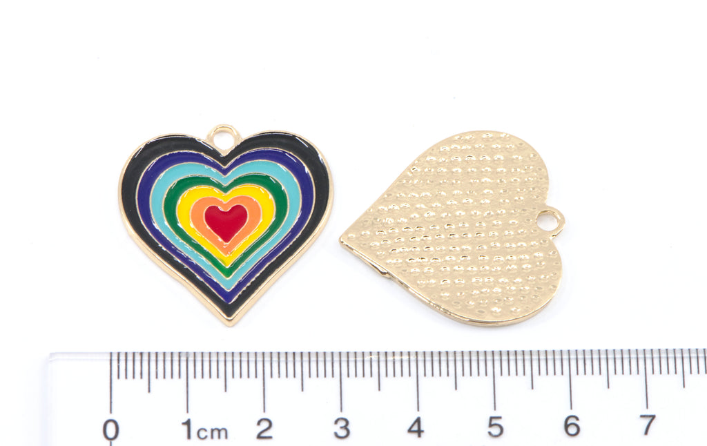 Two heart-shaped jewelry charms shown on a white background with a ruler at the bottom for scale.