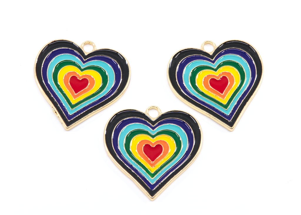 Three heart-shaped enamel jewelry charms with concentric rainbow heart designs and gold-tone borders, arranged on a plain white background.