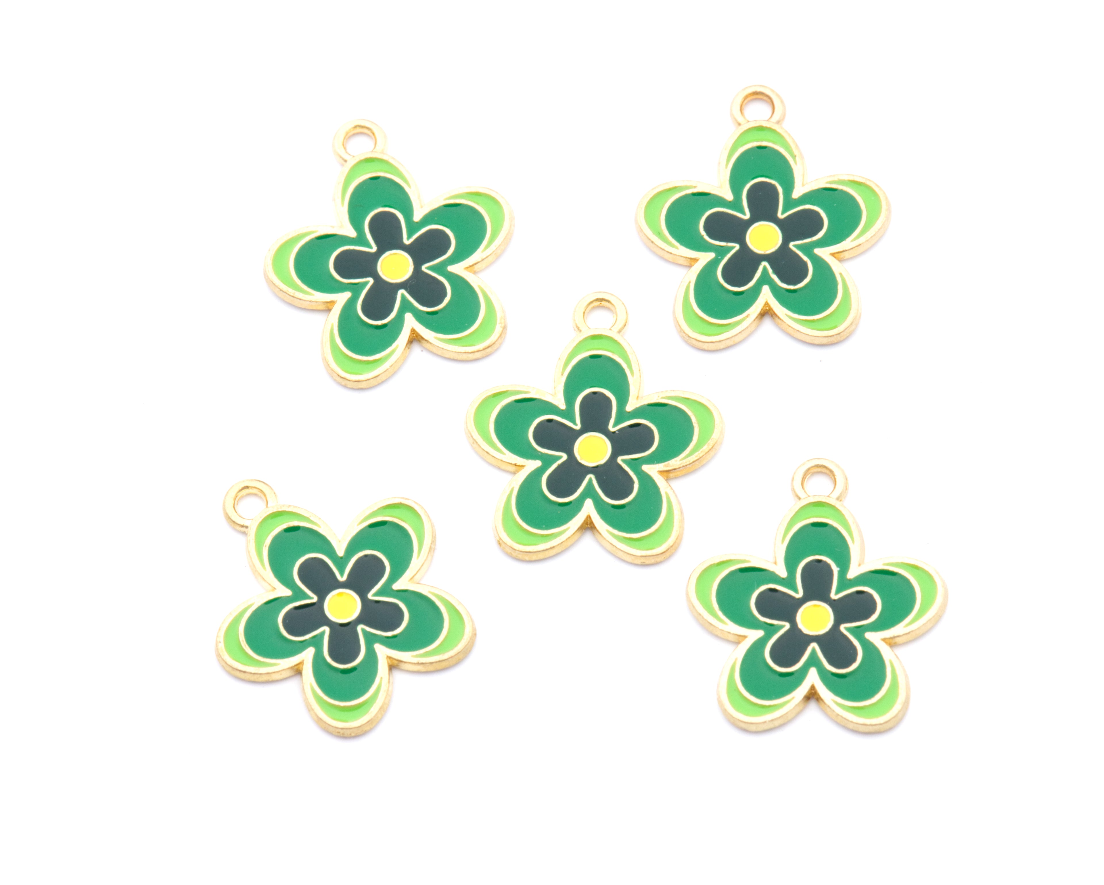 Five small flower-shaped jewelry charms with green petals, yellow centers, and gold-tone edges, arranged on a plain white background.