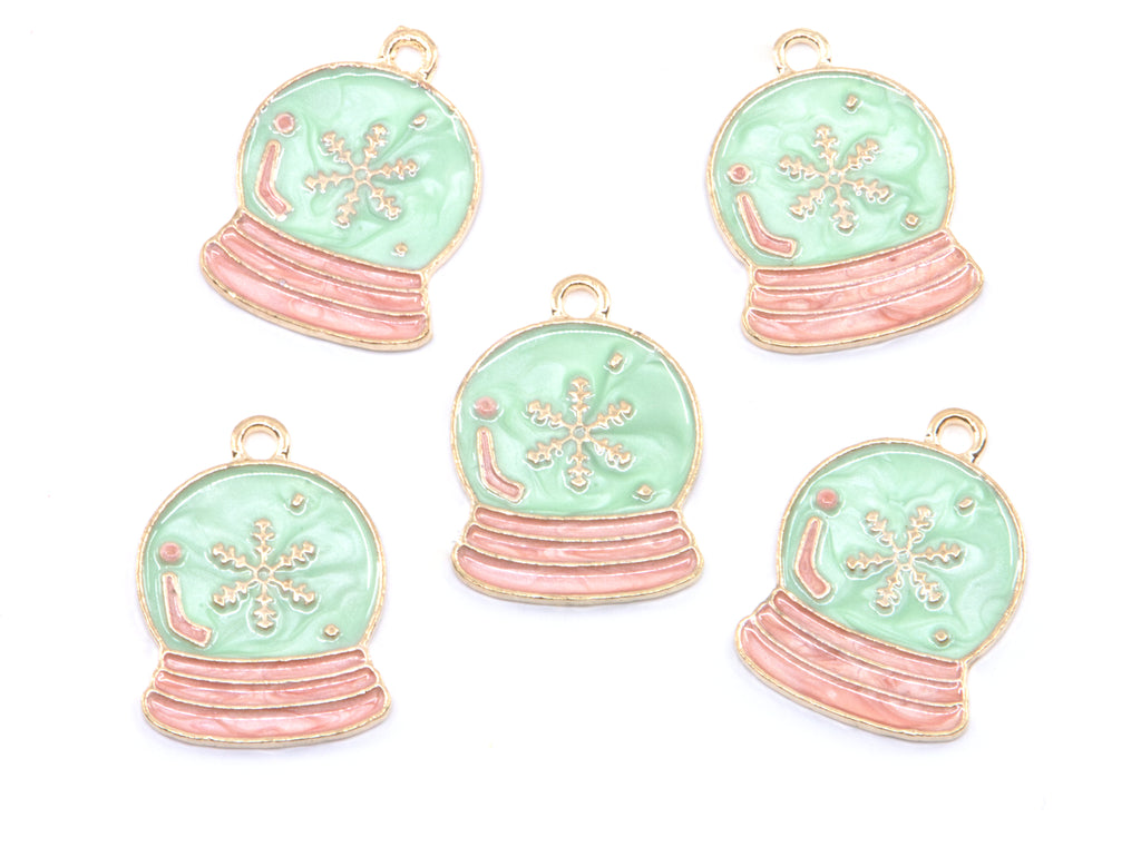 Five snow globe jewelry charms with light blue enamel, pink striped bases, and gold-tone metal borders on a white background.