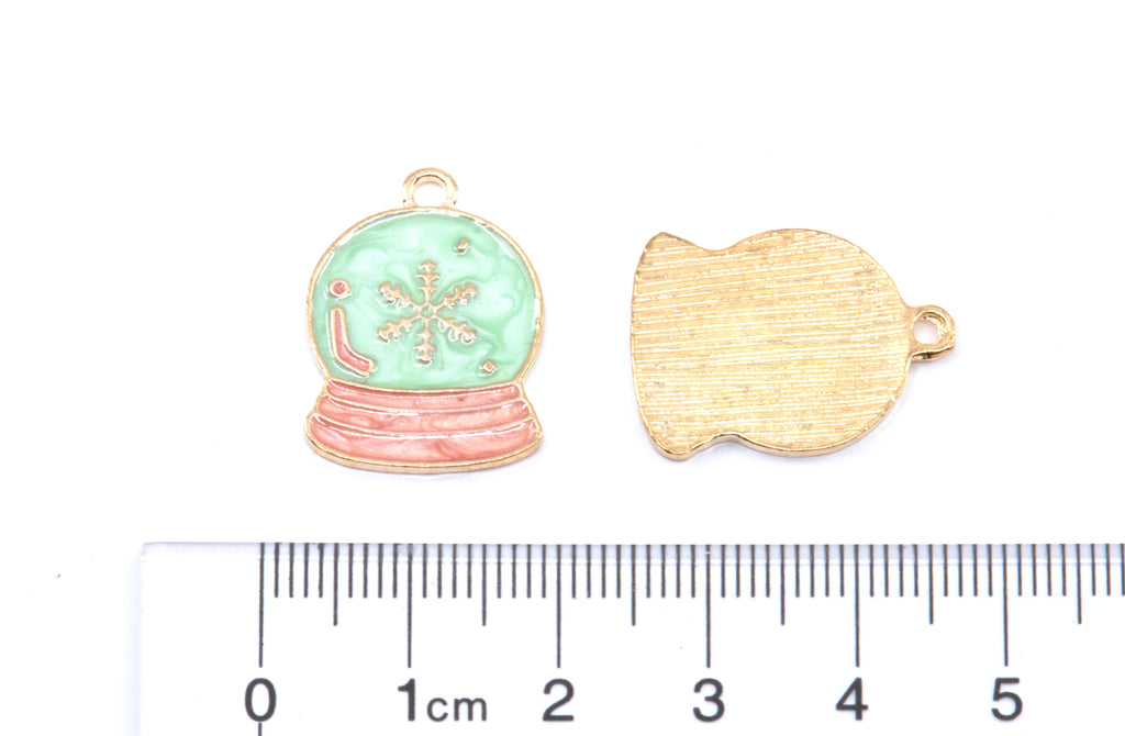 Two blue and pink snow globe jewelry charms shown on a white background with a ruler at the bottom for scale: 