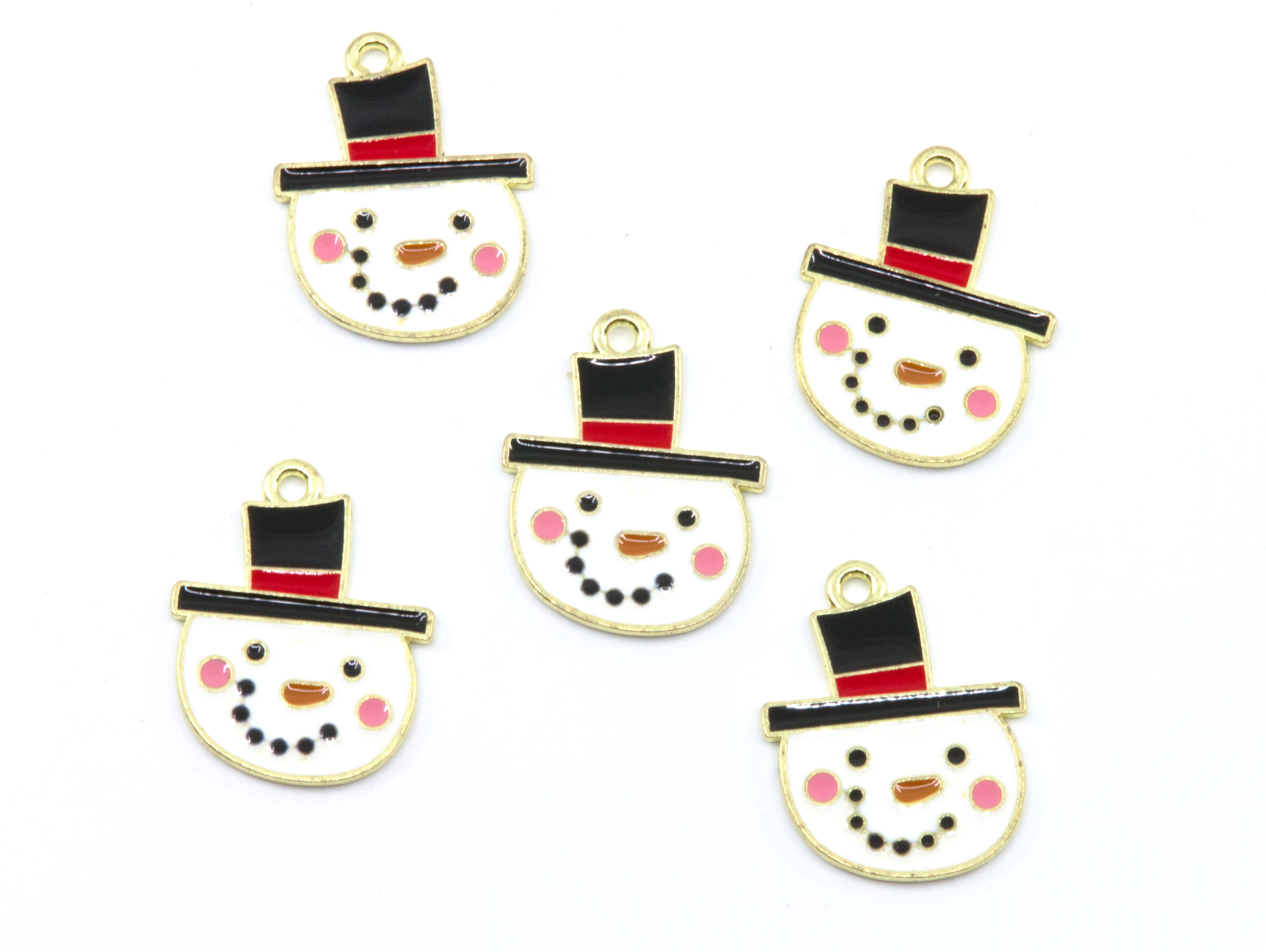 Five snowman face charms with gold-tone metal borders, black top hats, red bands, pink cheeks, and black dot facial features on a white background.
