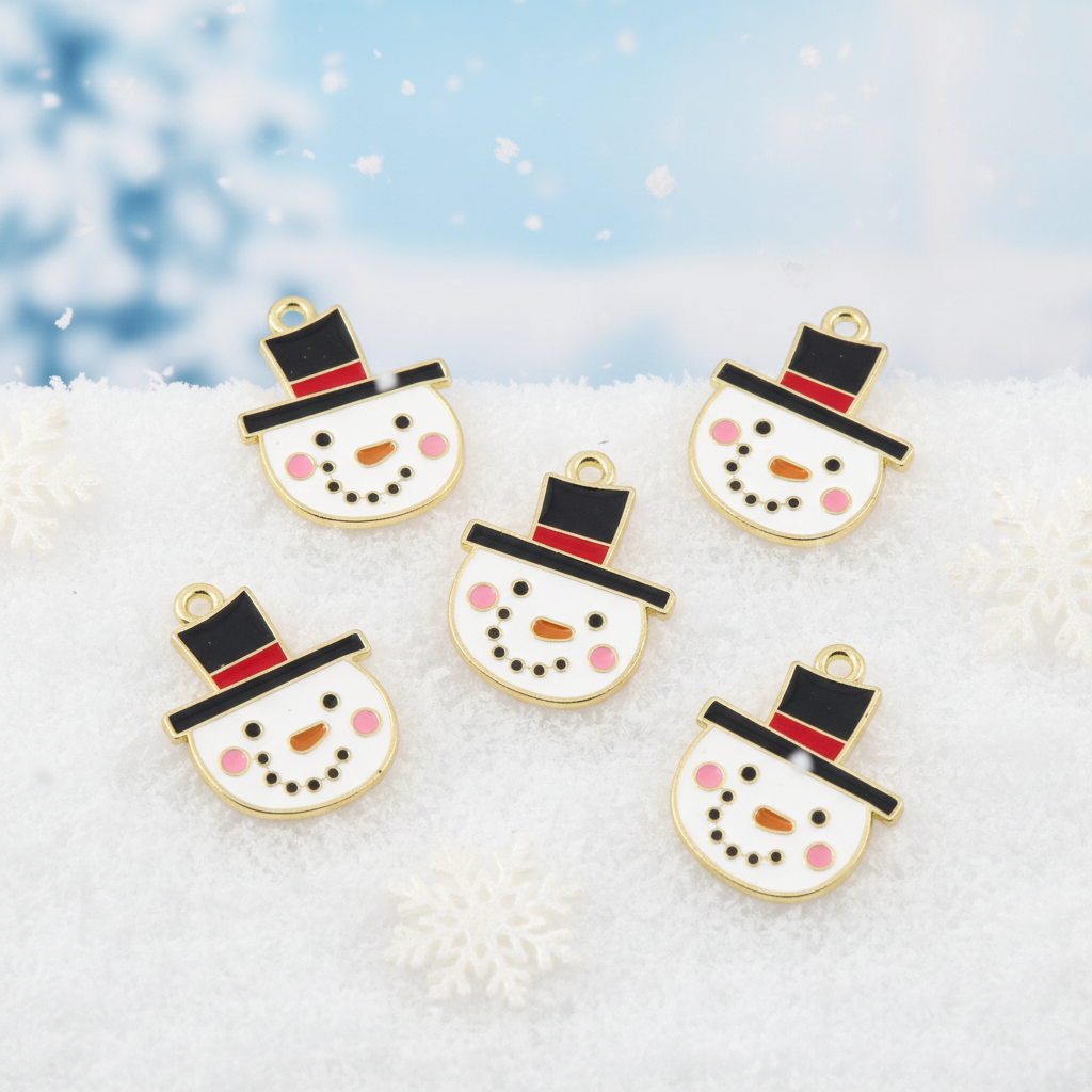 Five snowman face charms with gold-tone metal borders, black top hats, red bands, pink cheeks, and black dot features, arranged on a white textured surface with a soft blue snowy background.