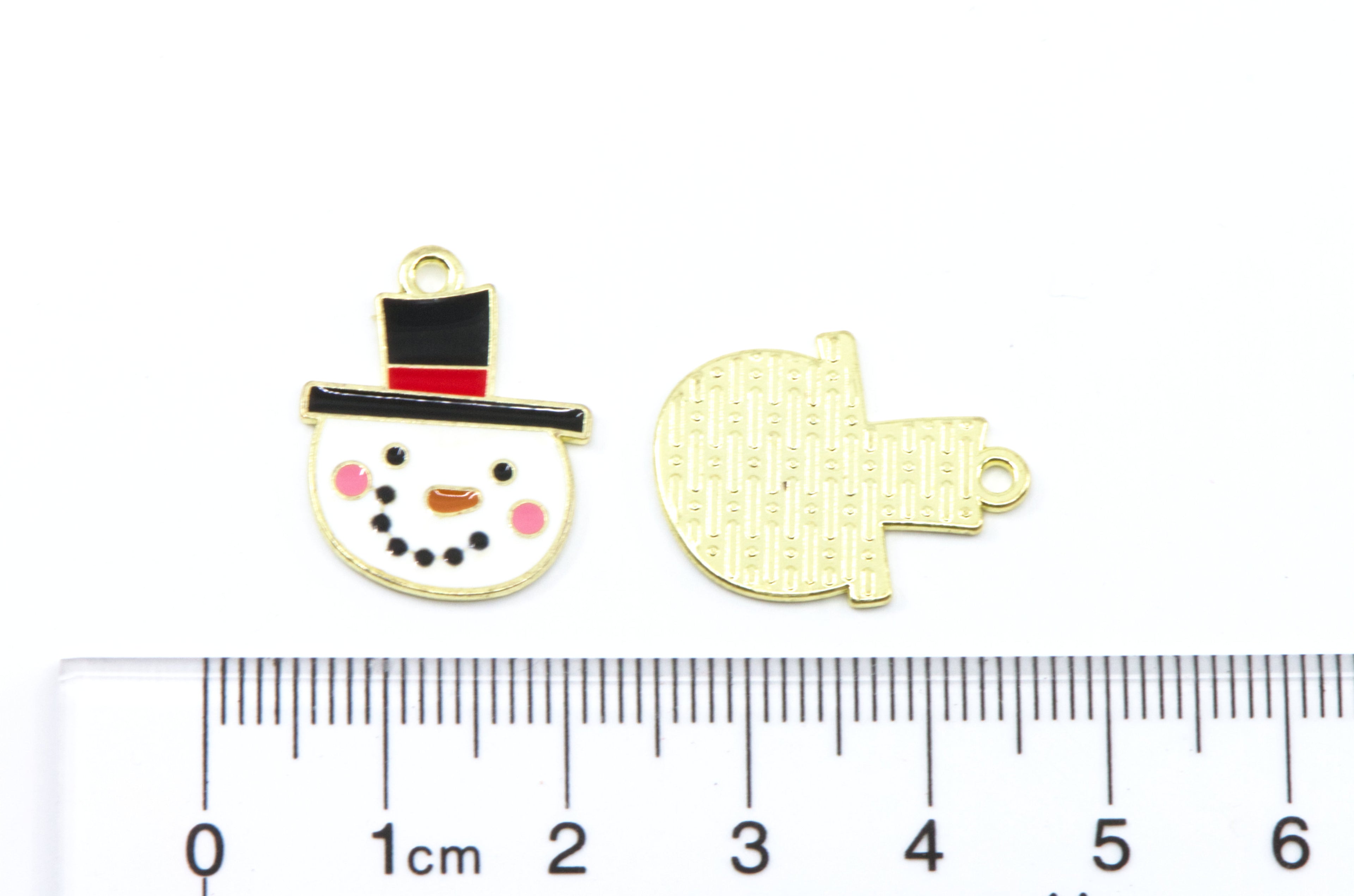 Two small gold-toned jewelry charms shown on a white background with a ruler at the bottom for scale. 