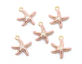 Five pink starfish charms with gold-tone metal outlines and loops, arranged on a plain white background.