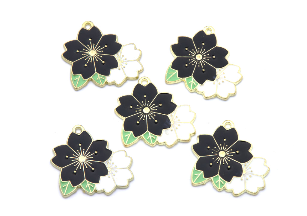 Five flower charms with black, white, and light green enamel details, arranged on a plain white background