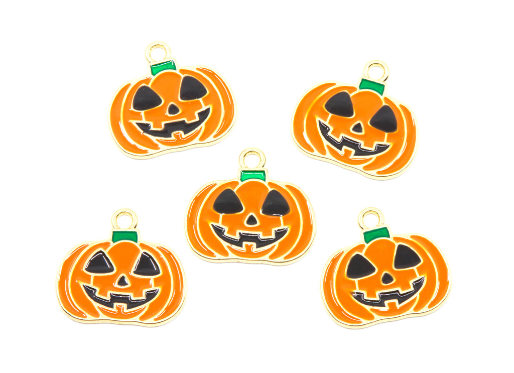Five orange jack-o'-lantern Halloween charms with black carved faces and gold-tone metal borders, arranged on a plain white background.