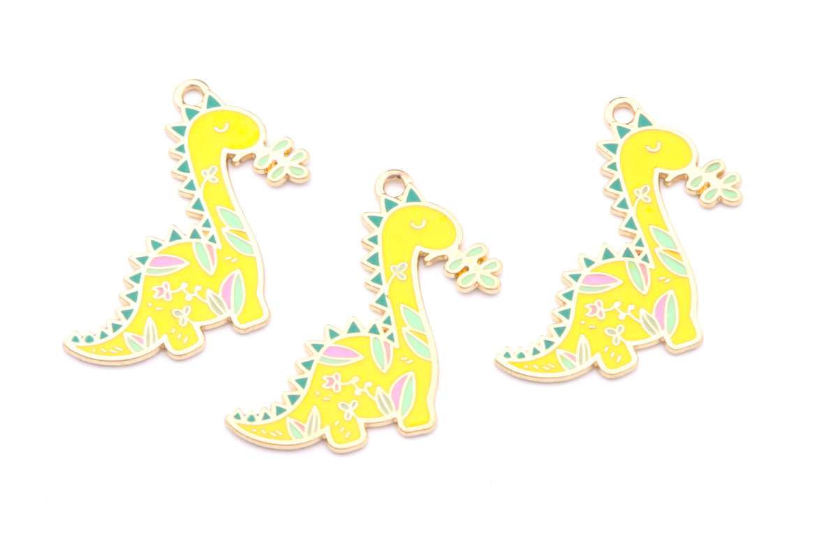 Three yellow dinosaur charms with colorful pastel patterns on a white background.