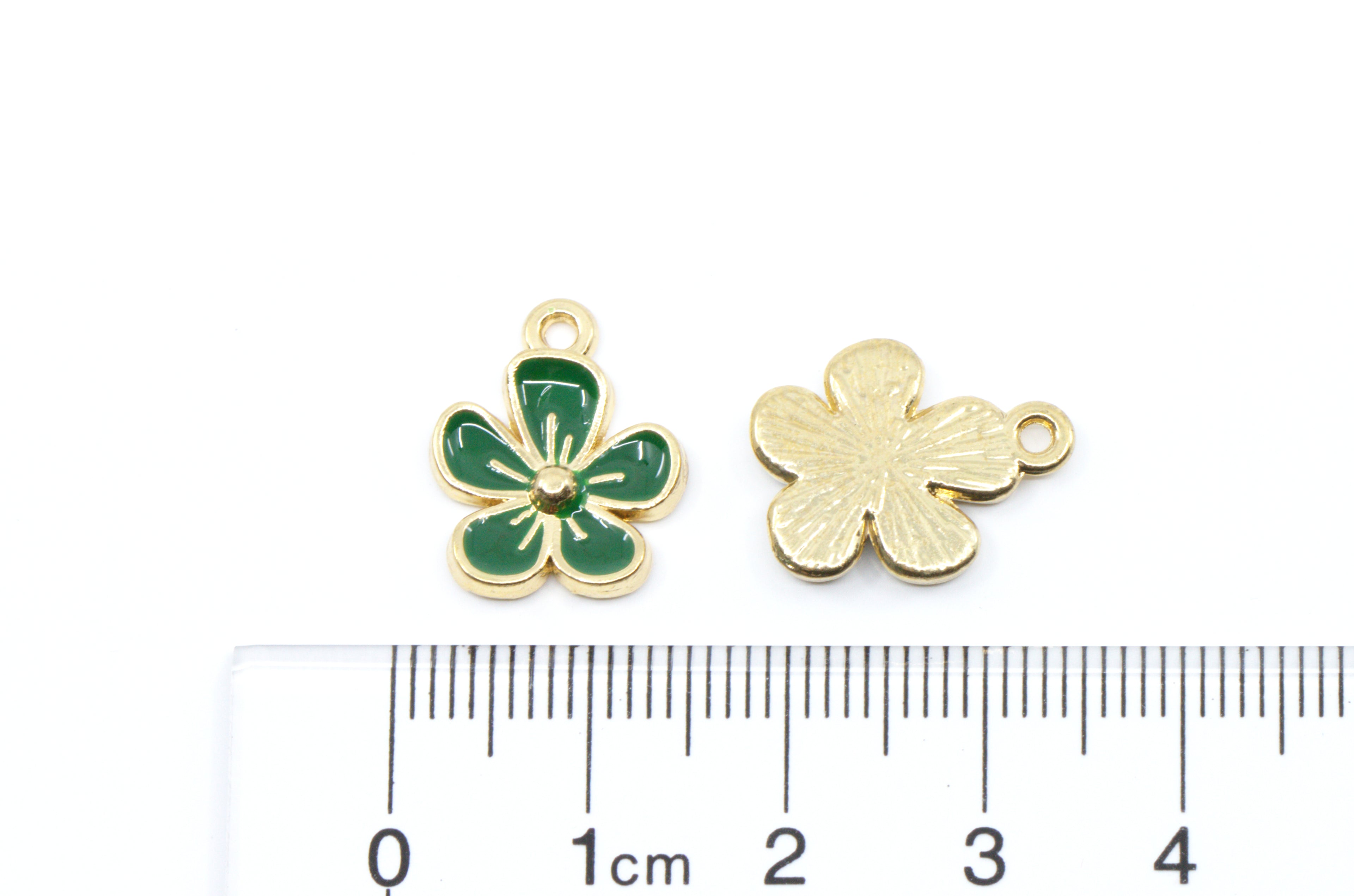 Two small flower charms, shown next to a cm ruler for scale on a white background.