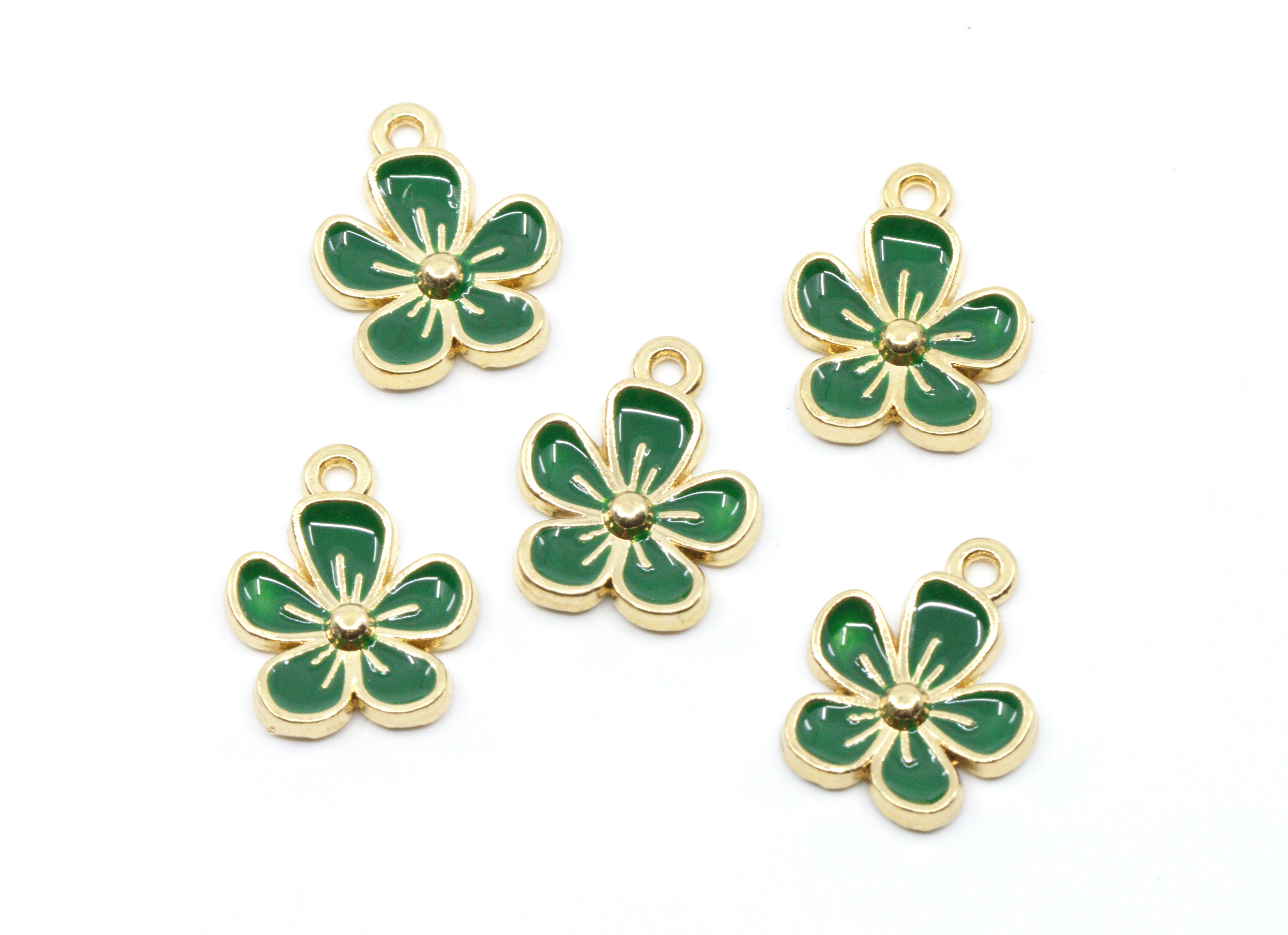 Five green enamel flower charms with gold-tone metal borders and loops, arranged on a plain white background.