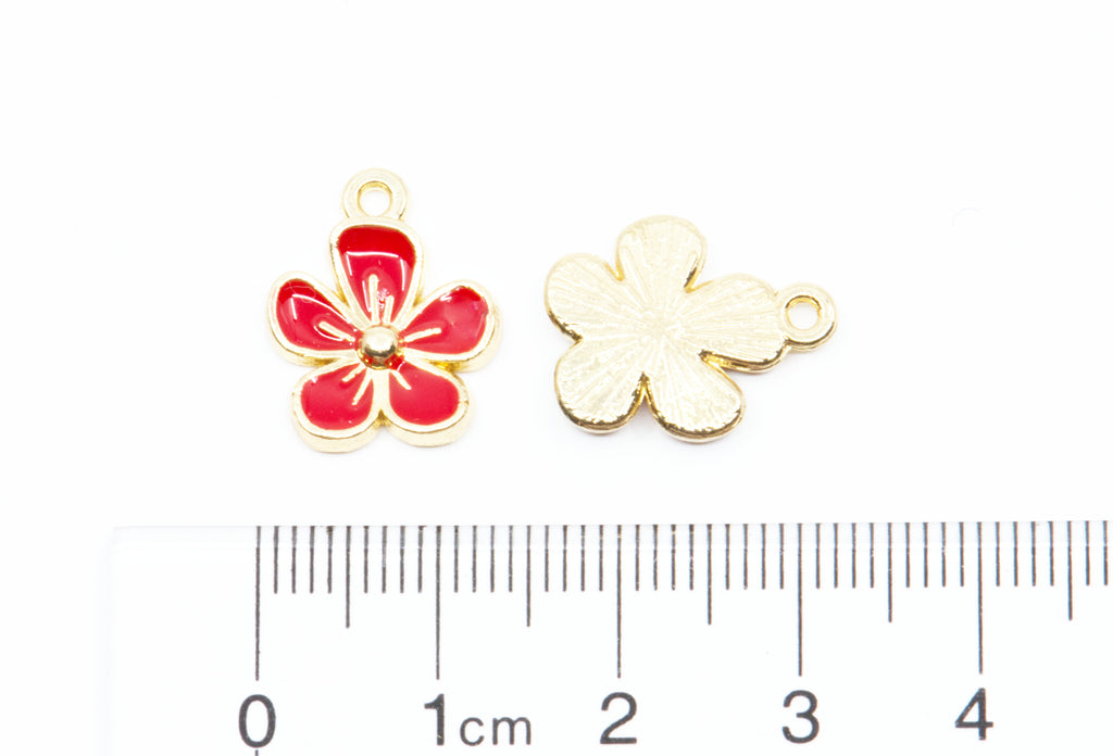 Two small flower-shaped jewelry charms on a white background, with a ruler at the bottom showing scale.
