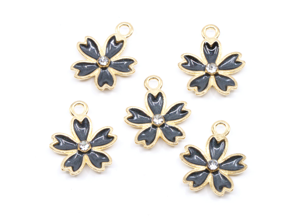 Five gray and gold flower-shaped jewelry charms with a clear rhinestone in the center, arranged on a plain white background.