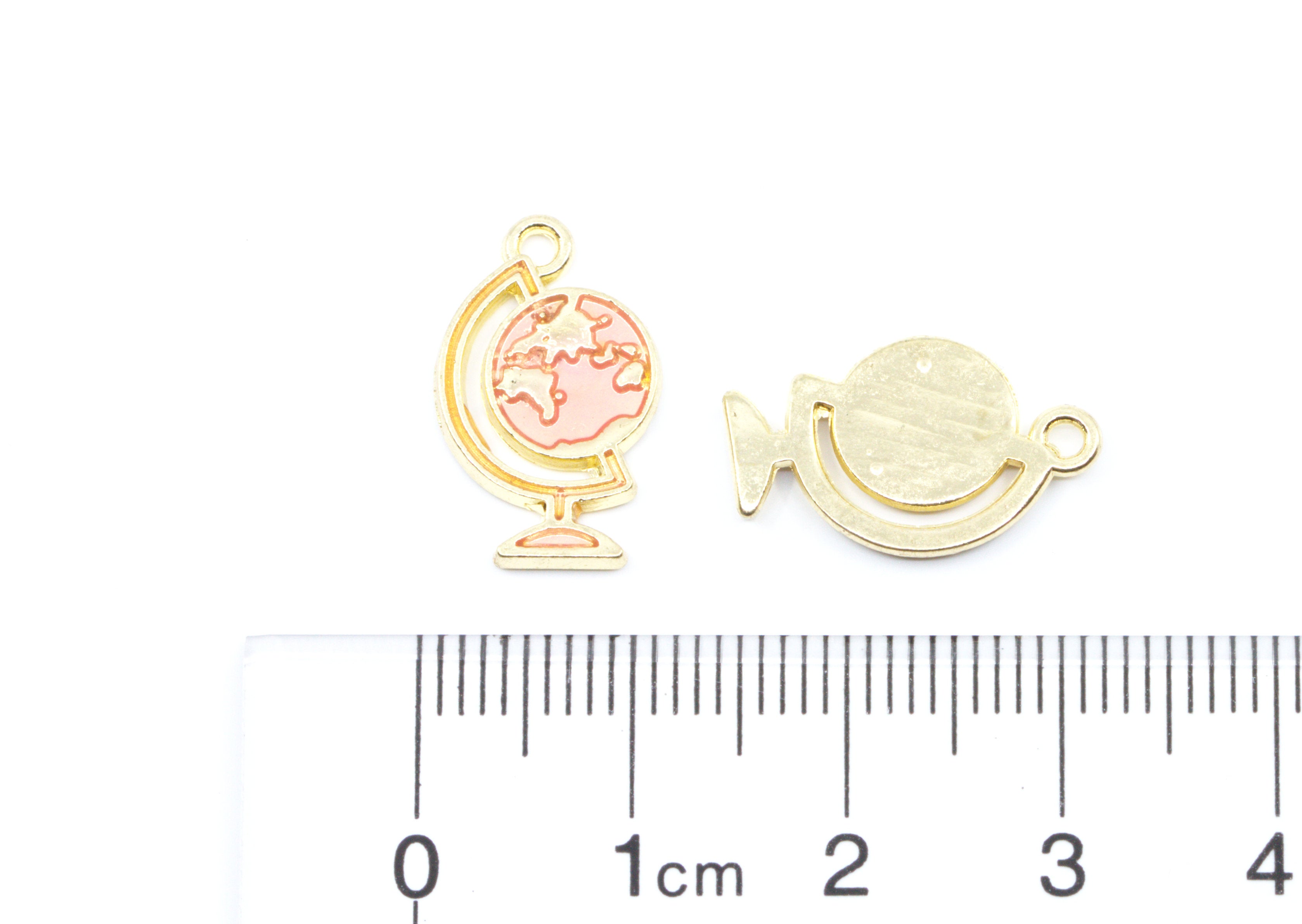 Two small gold-toned globe charms shown on a white background with a cm ruler below for scale.