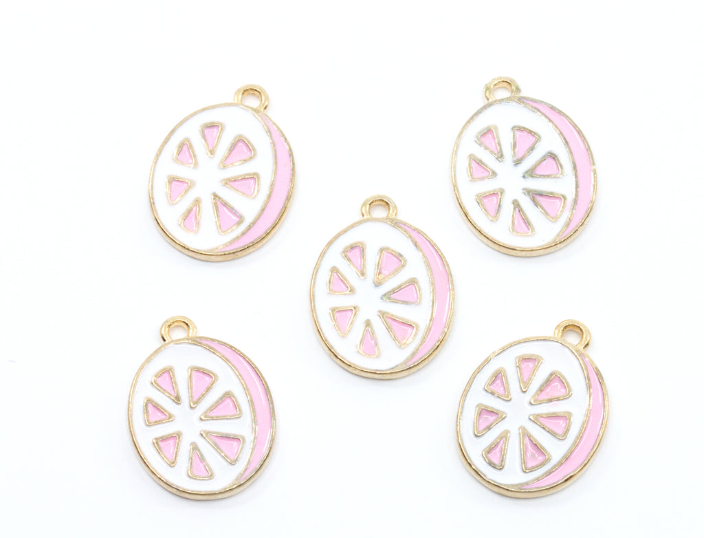 Five round enamel charms shaped like sliced  grapefruit, featuring a white center with pink segments and a gold-tone border, arranged on a plain white background.