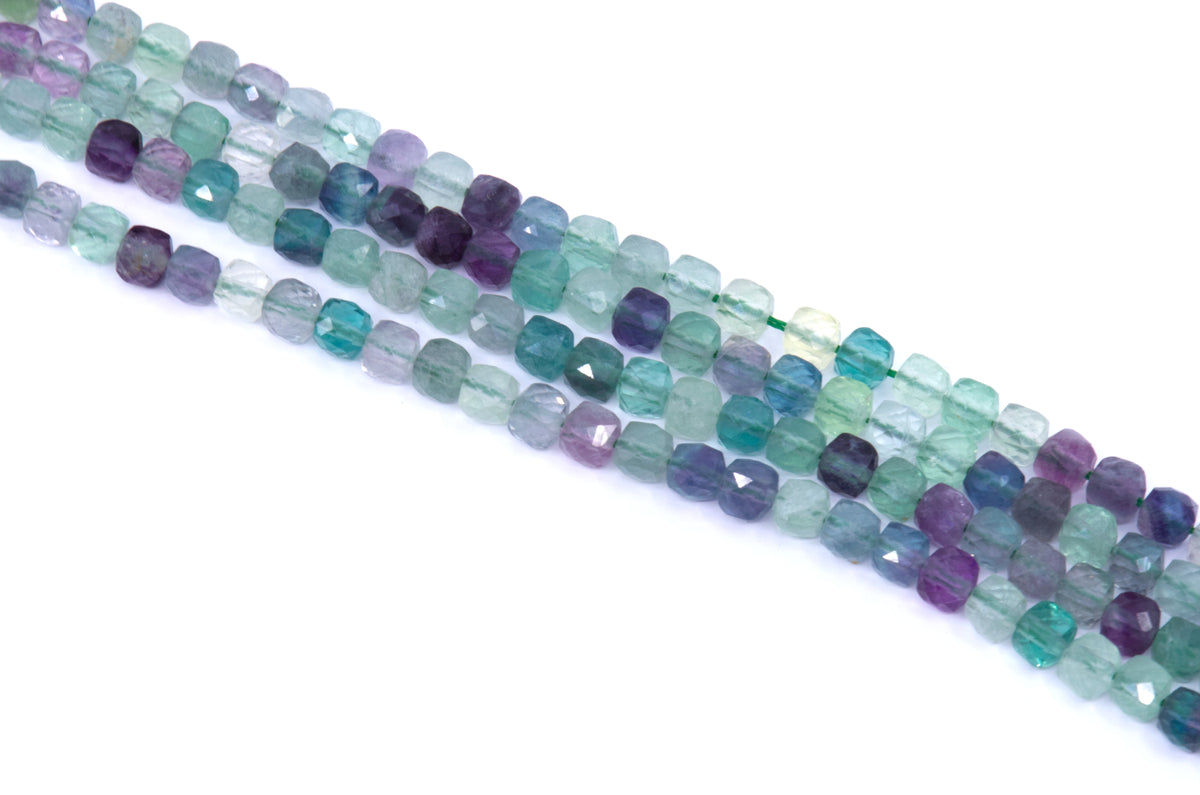 Four strands of faceted gemstone green fluorite beads in shades of teal, green, blue, and purple, arranged diagonally on a white background.