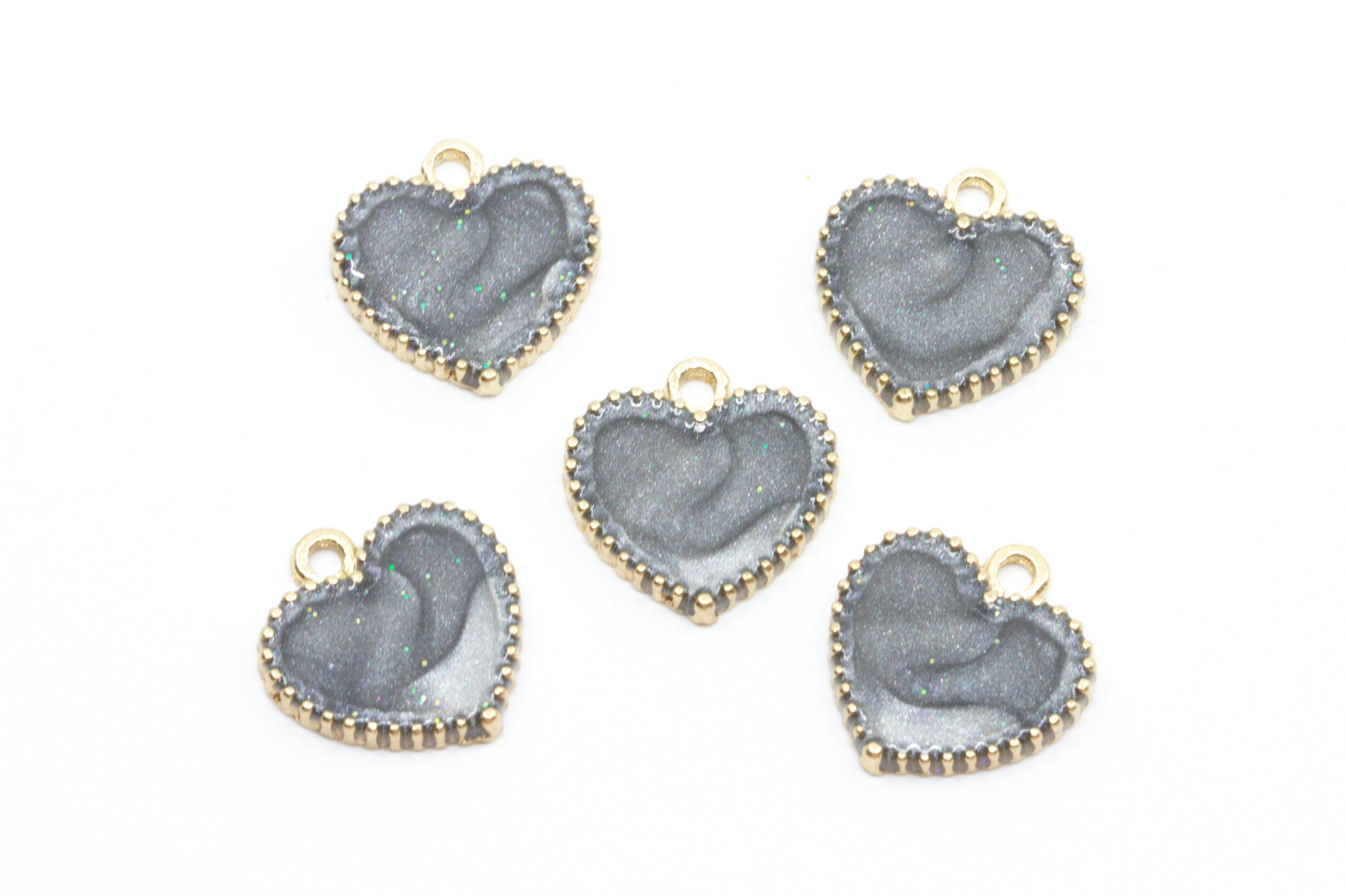 Five heart-shaped jewelry charms with a  gray center and gold-tone edges, arranged on a plain white background.