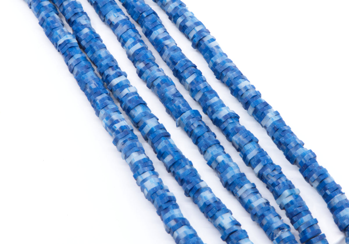 multiple strands of blue and white polymer clay hexagon disc beads arranged diagonally on a plain white background.
