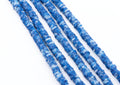 multiple strands of blue and white polymer clay hexagon disc beads arranged diagonally on a plain white background.