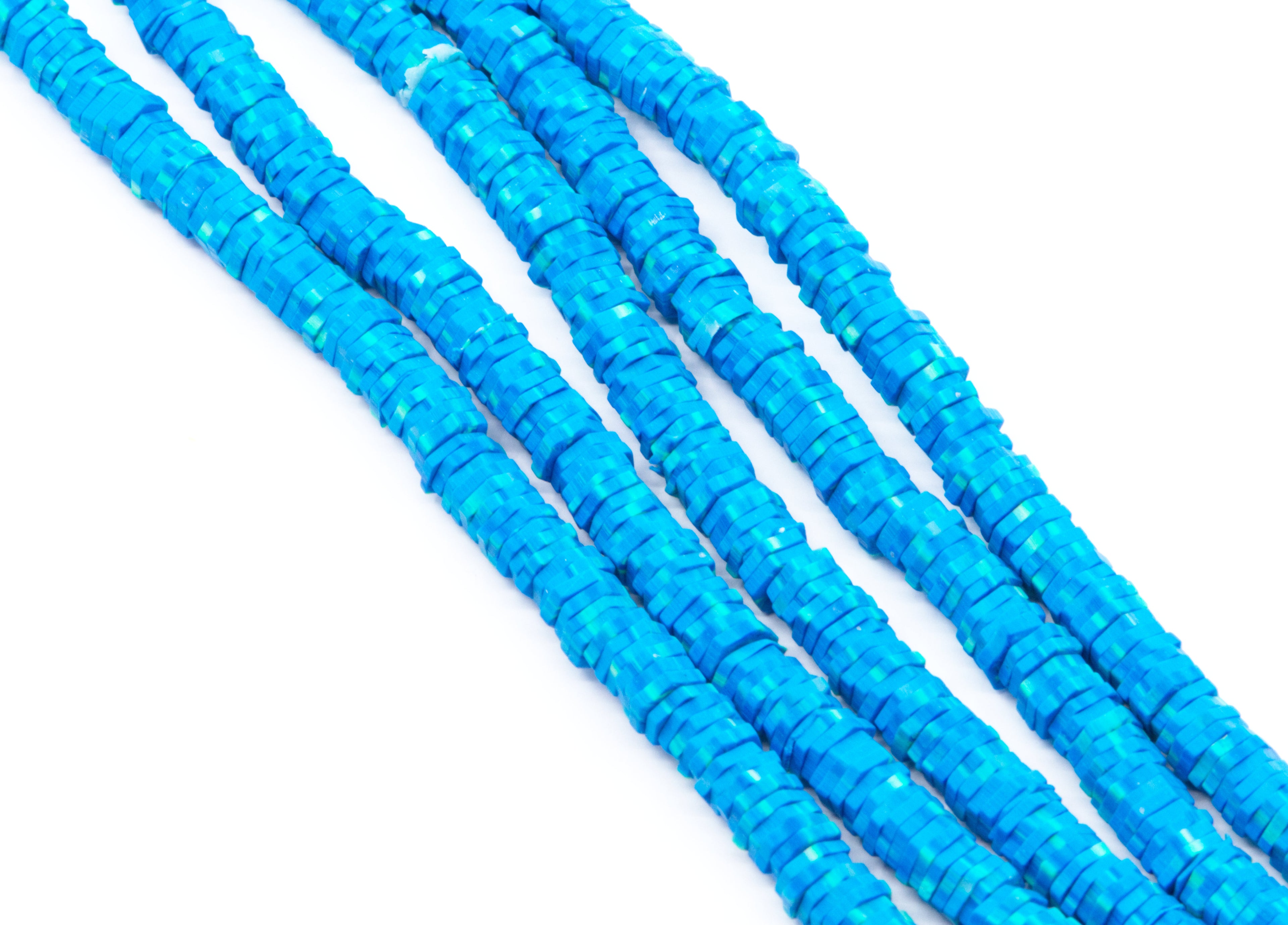 Multiple strands of bright blue polymer clay hexagon disc beads, arranged diagonally on a plain white background.