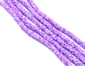 multiple strands of purple polymer clay hexagon disc beads arranged in diagonal strands on a white background.