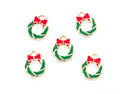Five small holiday wreath charms with gold-tone metal edges, green enamel fill, and red bow details, arranged on a plain white background.