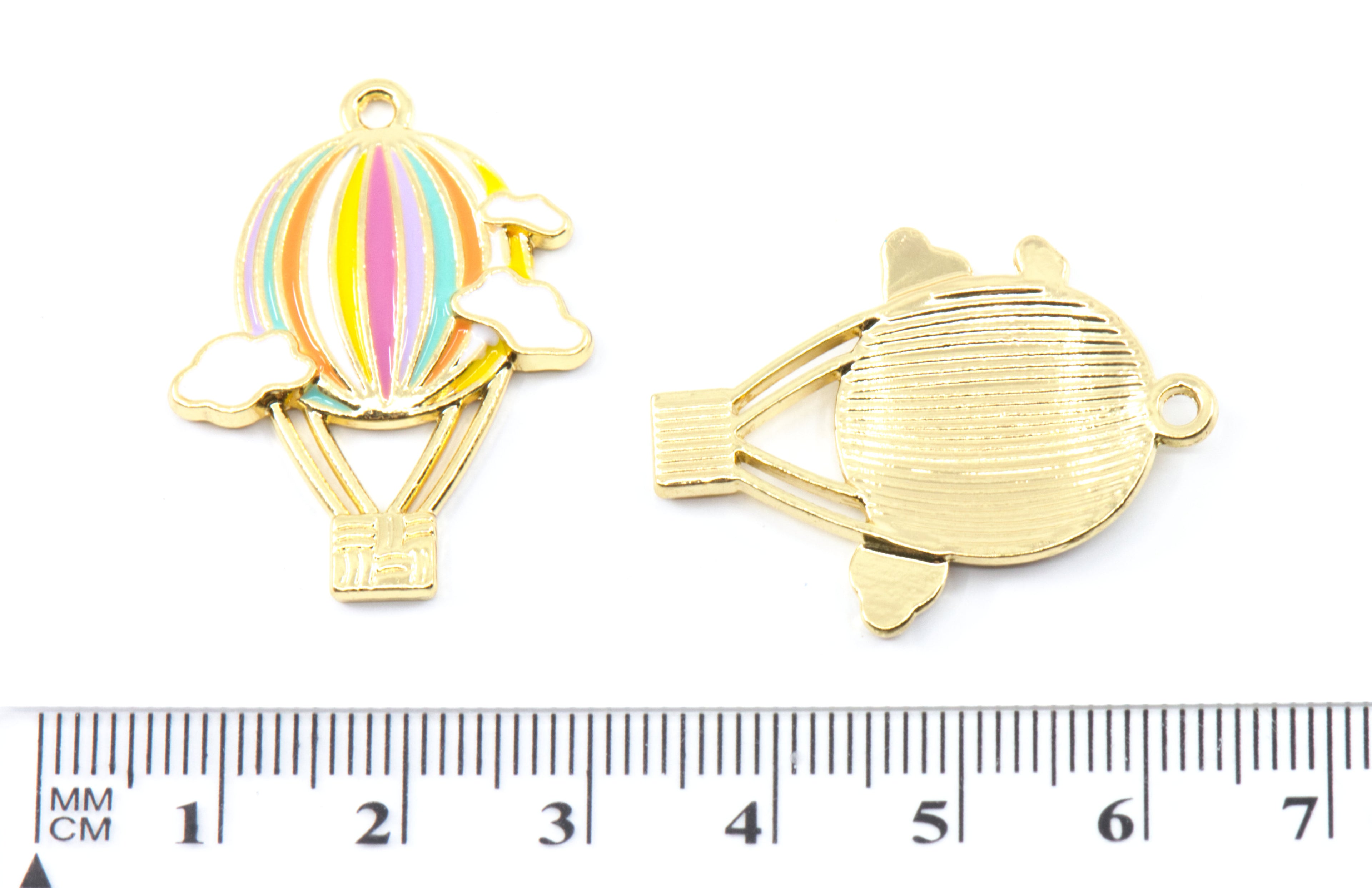 Two gold-toned hot air balloon charms shown on a white background, one front view and one back view, with a black ruler at the bottom indicating scale in millimeters.