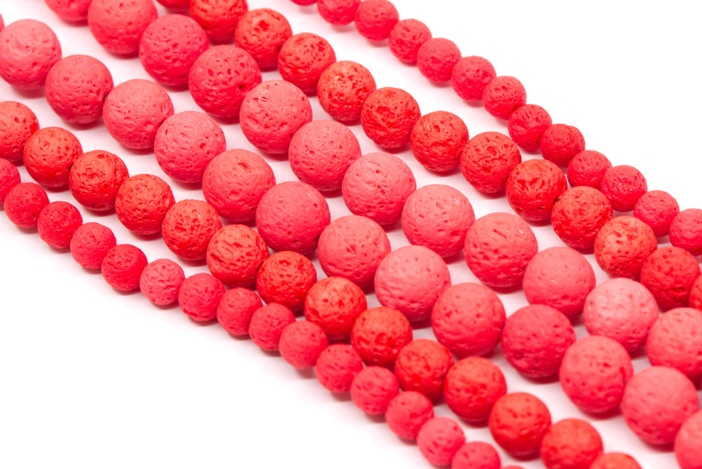 Multiple strands of textured red  lava stone beads arranged diagonally on a clean white background.