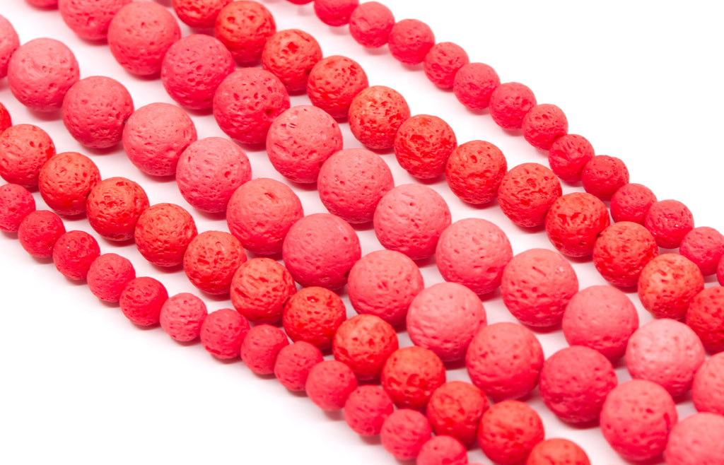 Multiple strands of textured red  lava stone beads arranged diagonally on a clean white background.