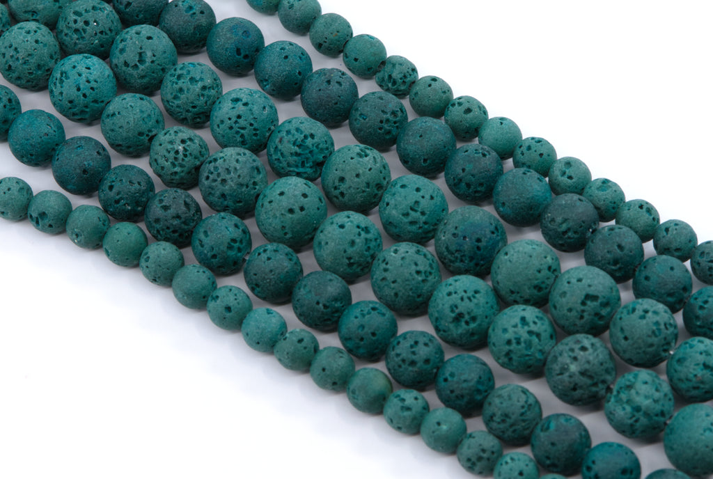 Multiple strands of porous lava stone beads in a dark teal-green color, arranged diagonally on a plain white background.