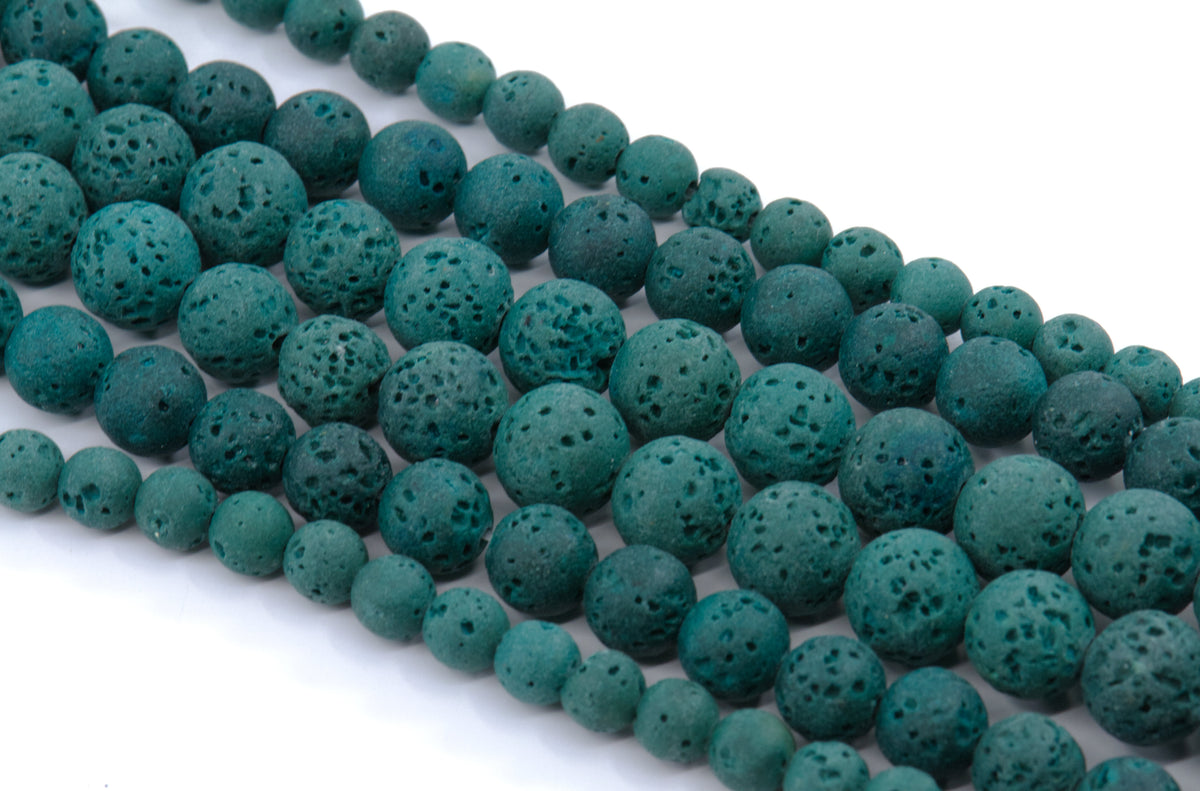 Multiple strands of porous lava stone beads in a dark teal-green color, arranged diagonally on a plain white background.